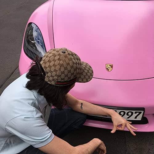 German rapper rb wearing a gucci cap in front of a pink 911