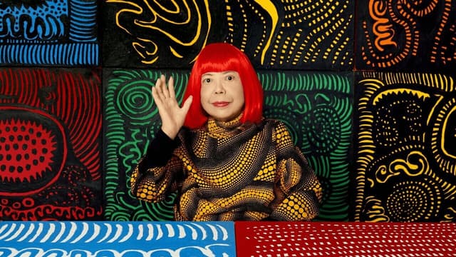 Yayoi Kusama in front of her paintings